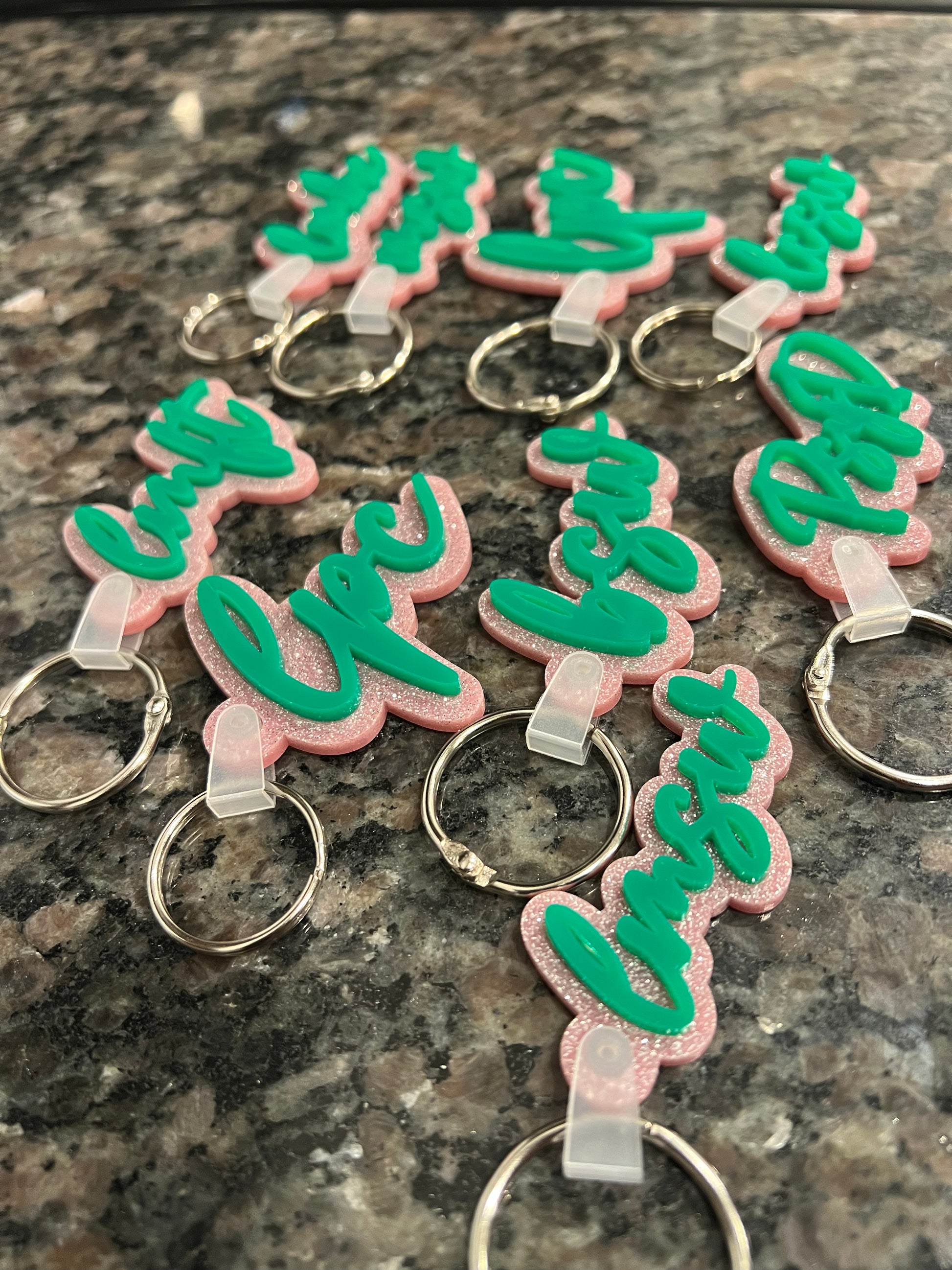 Glittered pink and green acrylic MH credential keychains.